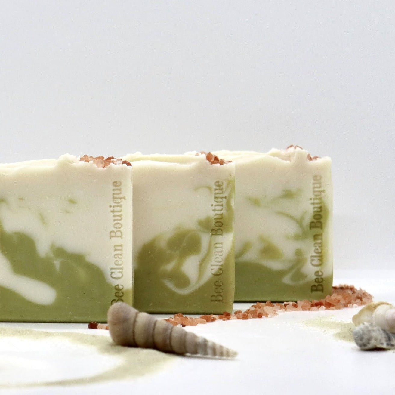 3 bars of salt and sage bar soaps surrounded by sea shells and pink sea salt