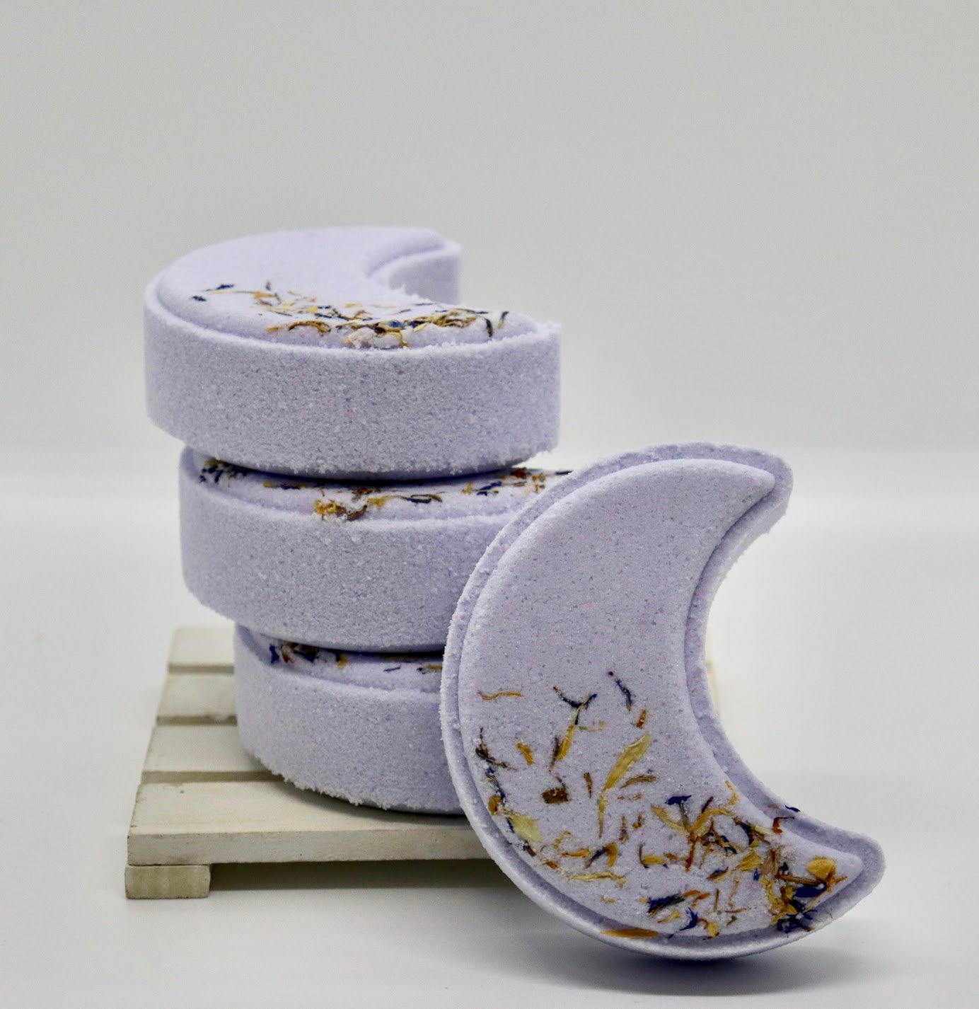 Moon shaped purple bath bombs in a stack