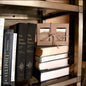 Two bars of beer soap bundled in a kraft paper box with string displayed on a book shelf